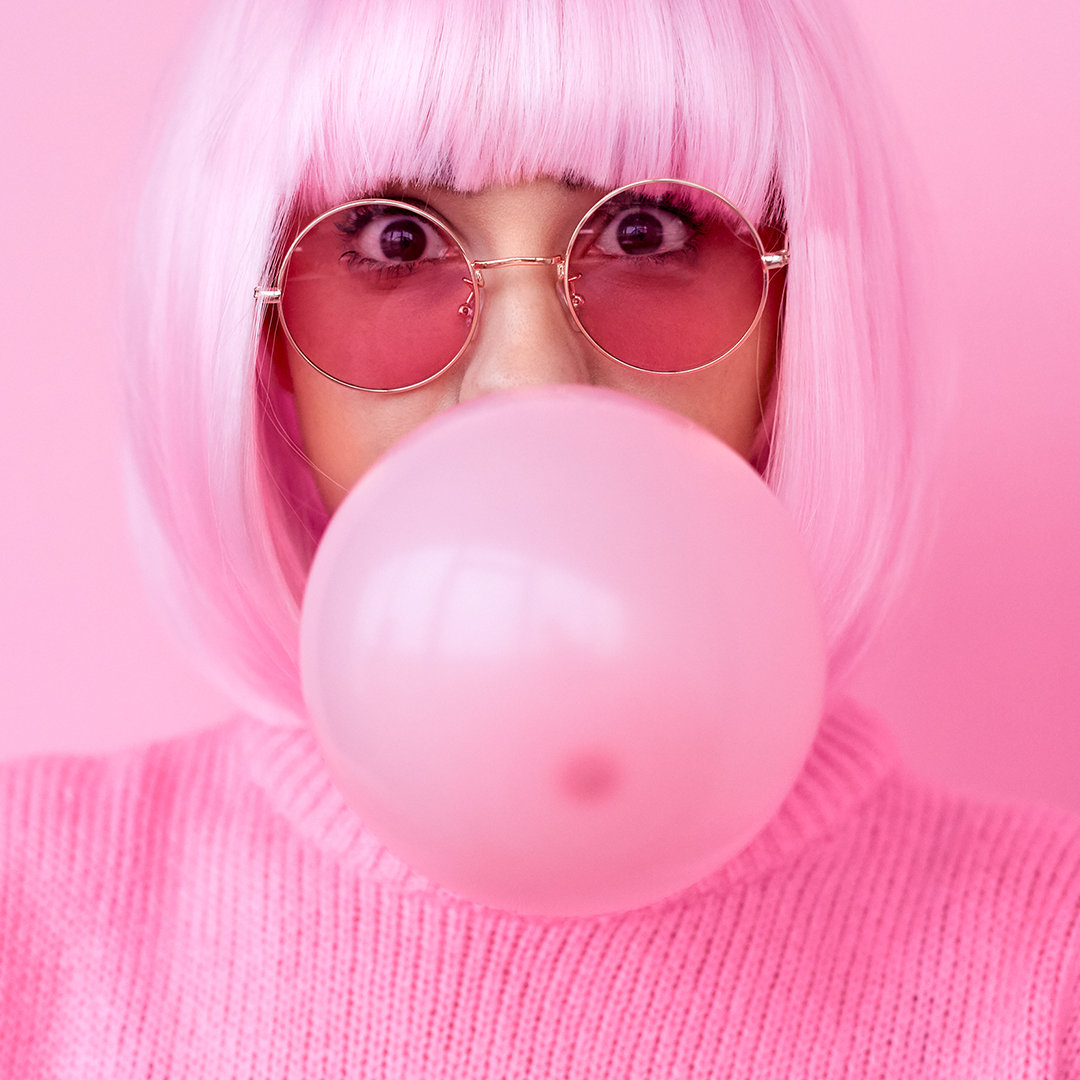 Girl blowing up pink gum in bubble